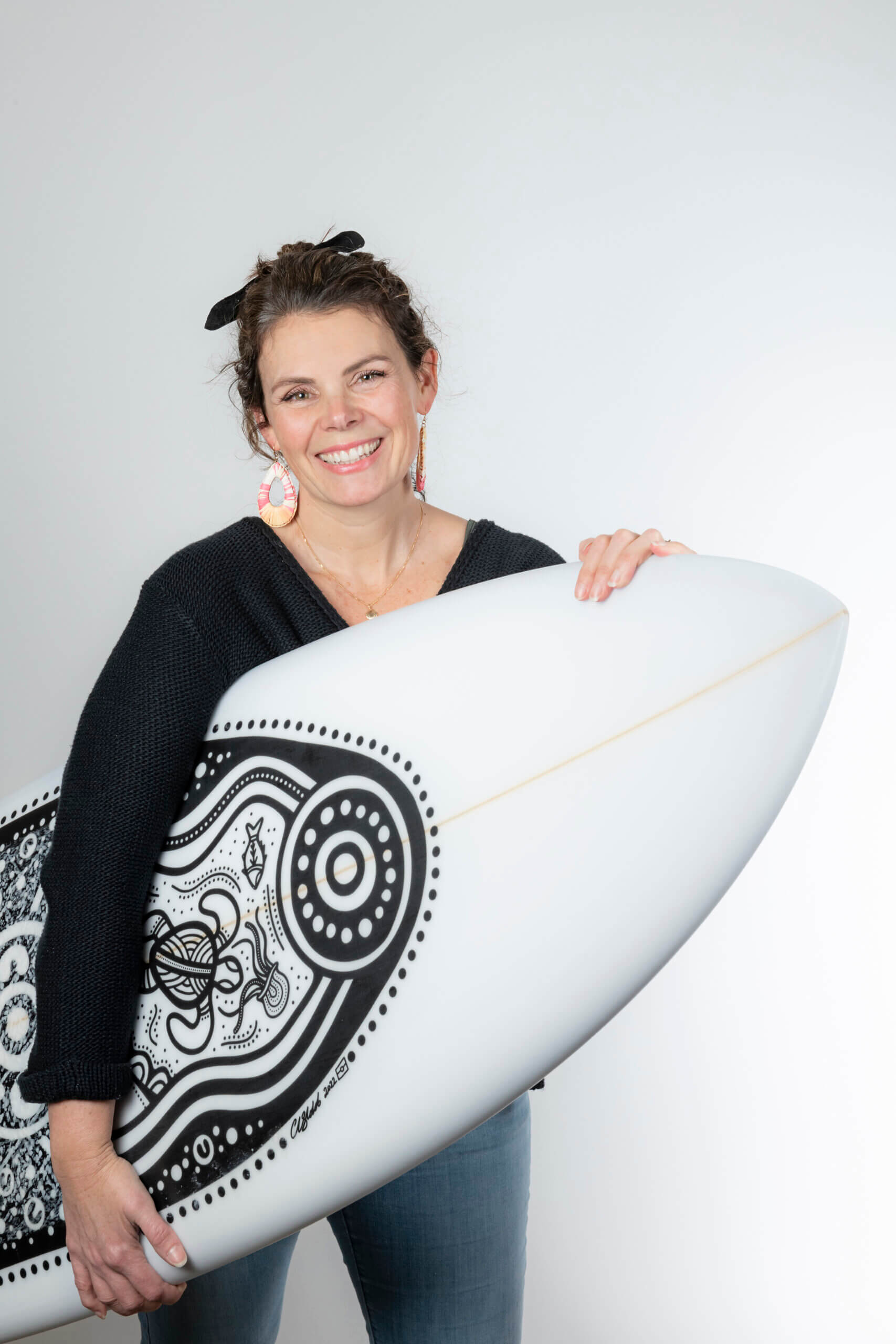 Kate Thompson holding surfboard